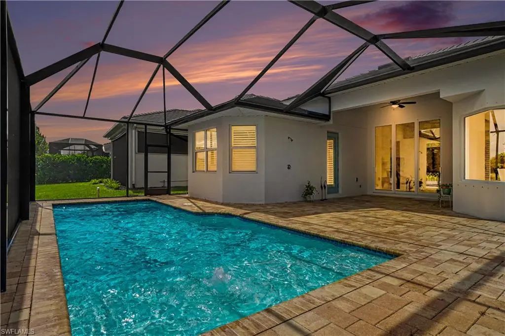 Screened lanai and gas-heated pool at sunset overlooking the lake at 9062 Montserrat Drive in Azure at Hacienda Lakes