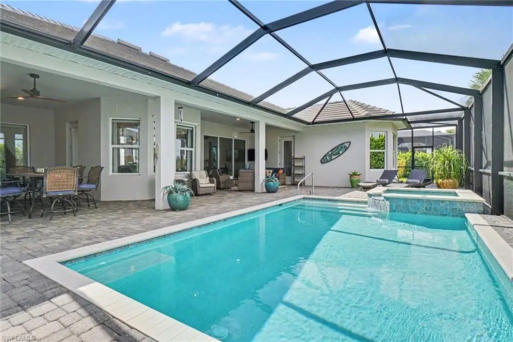 Gas-heated pool and spa inside the screen enclosure at 15880 Talon Terrace, Punta Gorda, FL, with the lanai and house behind
